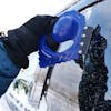 Snow Joe Ice Dozer Ice and Snow Scraper Tool using the Squeegee Brush on a car window.