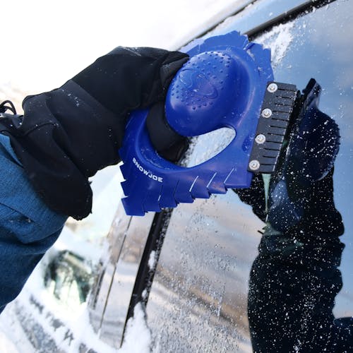 Snow Joe Ice Dozer Ice and Snow Scraper Tool using the Squeegee Brush on a car window.