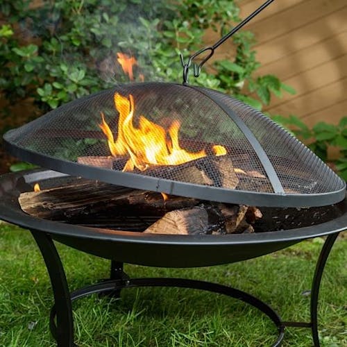 Wood burning in the Sun Joe 30-Inch Round Steel Fire Pit with the dome screen on top.