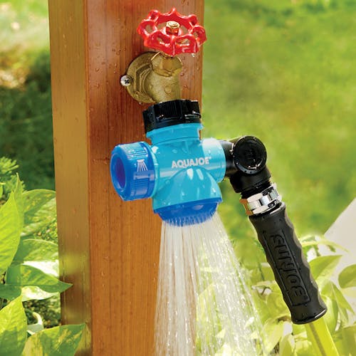 Aqua Joe Multi-Function Outdoor Faucet and Garden Hose Tap Connector attached to a garden hose and spraying water.