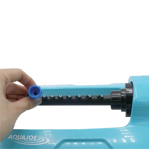 Cleaning pin being used on the nozzles of the Aqua Joe 20-nozzle Indestructible Jumbo Metal Base Oscillating Sprinkler.