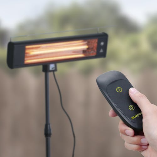Remote being used to turn on the Sun Joe Water-Resistant Electric Indoor and Outdoor Patio Infrared Heater.