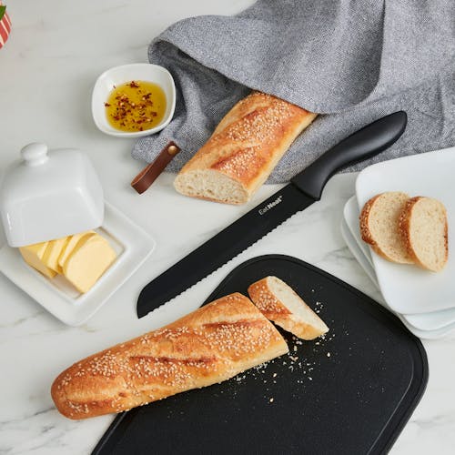 Bread on the cutting board with a bread knife on the kitchen counter.