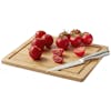 Cutting board for the EatNeat 8-piece knife set with a knife and tomatoes on it.