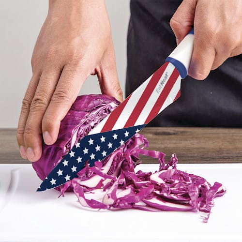 American flag chef's knife being used to cut an onion.