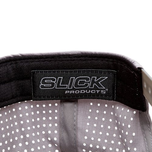 Close-up of the Slick Products tag inside the one-size-fits-all gray micro tech snapback hat.
