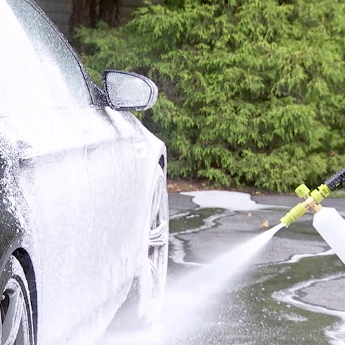 Sun Joe foam cannon being used with the Sun Joe 1-gallon Pineapple Scented Premium Snow Foam Pressure Washer Rated Car Wash Soap and Cleaner to clean a car.