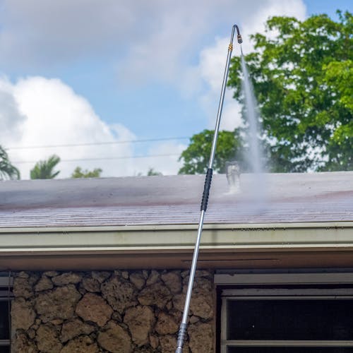 Sun Joe 9-Foot Universal Pressure Washer Sky Lance using the gutter attachment to clean a roof.