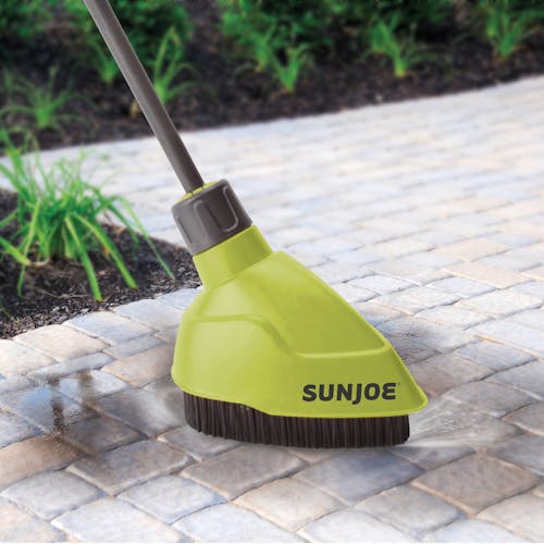Sun Joe Turbo Lance with Splash Guard Brush Attachment for pressure washers being used to clean paving stones.