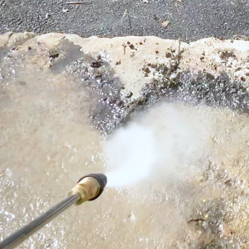 Sun Joe Universal Turbo Head Spray Nozzle for pressure washers cleaning a driveway.