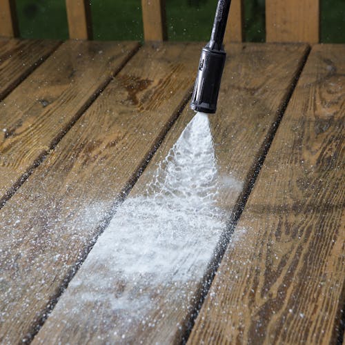 Sun Joe 11-amp Electric Pressure Washer with 1450 PSI being used to clean a deck.