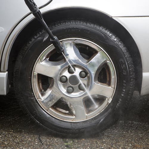 Sun Joe 11-amp Electric Pressure Washer with 1450 PSI being used to clean car tires.