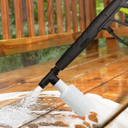 Sun Joe pressure washer detergent being used with a foam cannon to wash a patio deck.