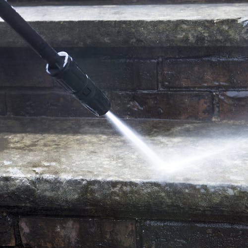 Spray wand being used to clean cement steps.