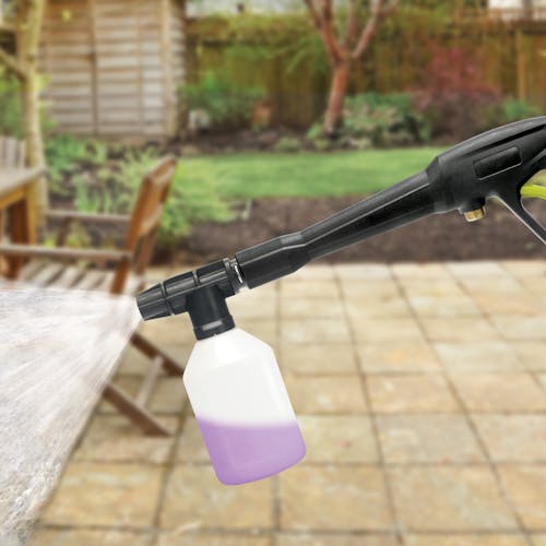 Foam cannon attachment being used to spray cleaning detergent.