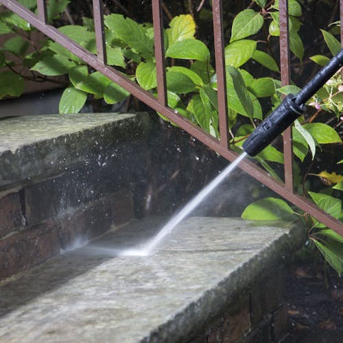 Spray wand being used to clean steps.