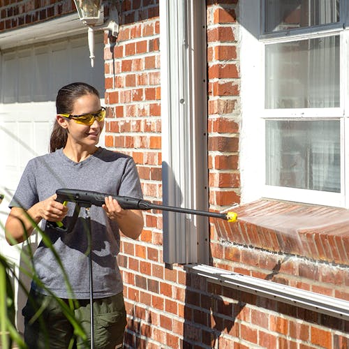Sun Joe 13-amp 1950 PSI Electric Pressure Washer being used to clean a brick wall.