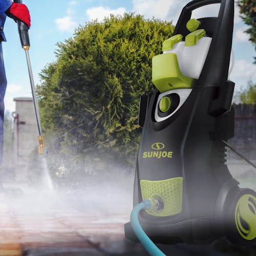 Sun Joe 14.5-amp 2800 PSI High-Performance Electric Pressure Washer being used to clean a driveway.