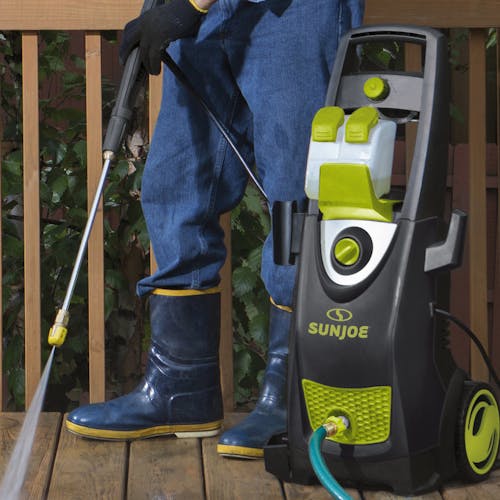 Sun Joe 14.5-amp 2800 PSI High-Performance Electric Pressure Washer being used to clean a wooden deck.