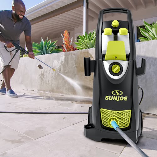 man using SPX3000-MAX to clean concrete wall