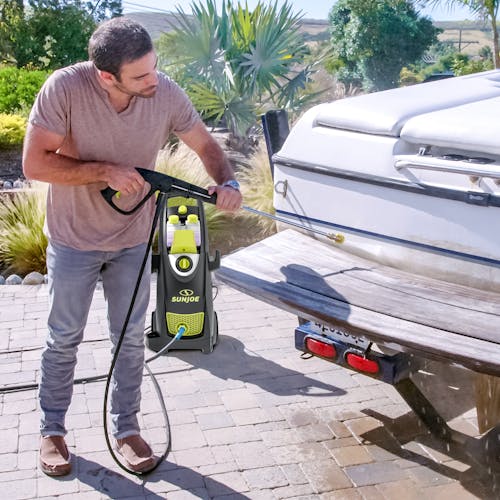 man using SPX3000-MAX to clean rear of boat