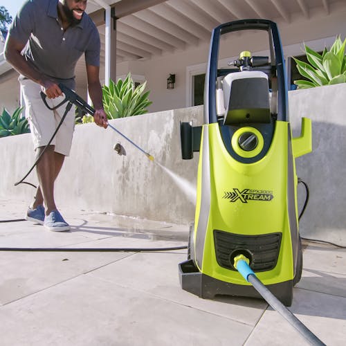 Sun Joe 13-amp 2200 PSI Extreme Clean Electric Pressure Washer being used to clean cement.