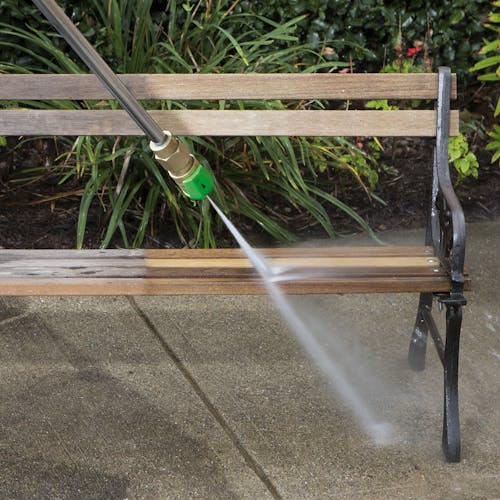 Spray wand being used to clean a bench.