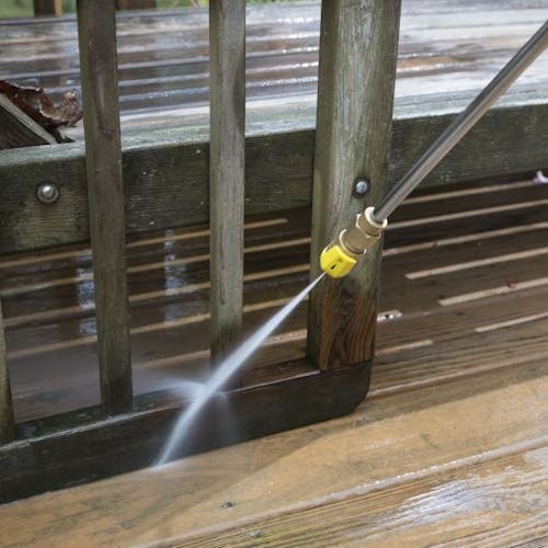 Spray wand being used to clean a patio deck.