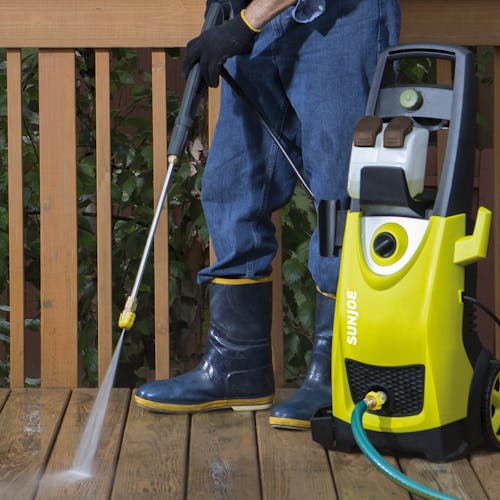 Sun Joe 14.5-amp 2030 PSI Electric Pressure Washer being used to clean a patio deck.