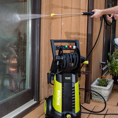 Sun Joe 14.5-amp 2030 PSI Electric Pressure Washer being used to clean a glass door.