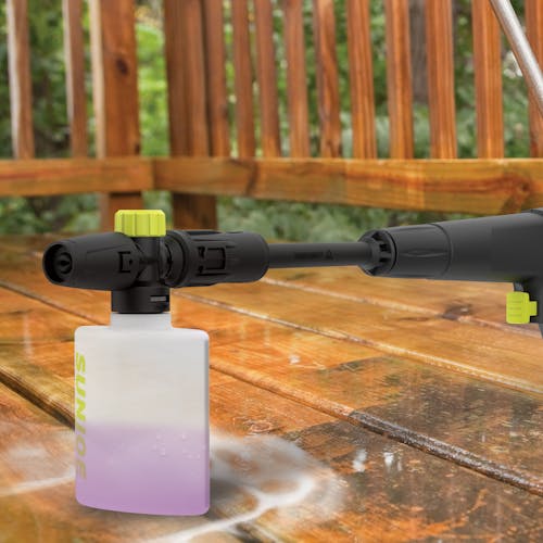 Spray wand with the foam cannon attachment on a patio deck.