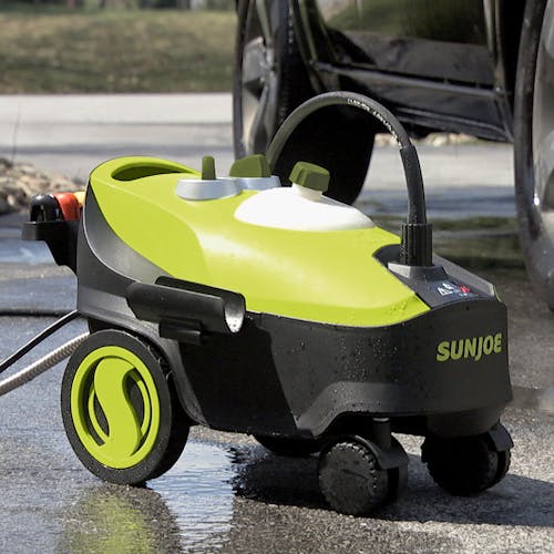 Sun Joe 14.5-amp 2030 PSI Portable Electric Pressure Washer in a driveway next to a car.