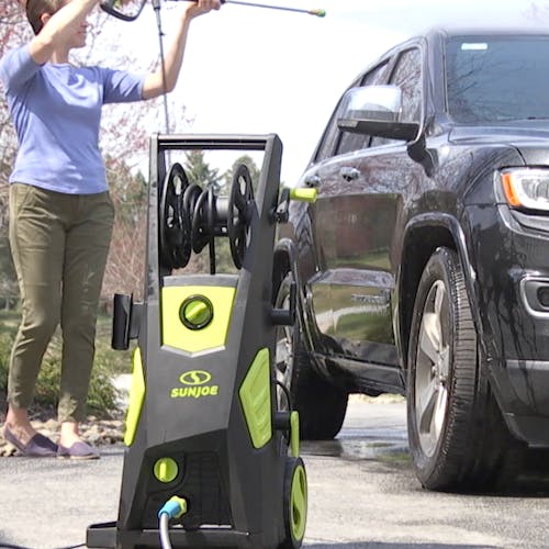 Sun Joe 13-amp 2250 PSI Brushless Induction Electric Pressure Washer being used to clean a car.