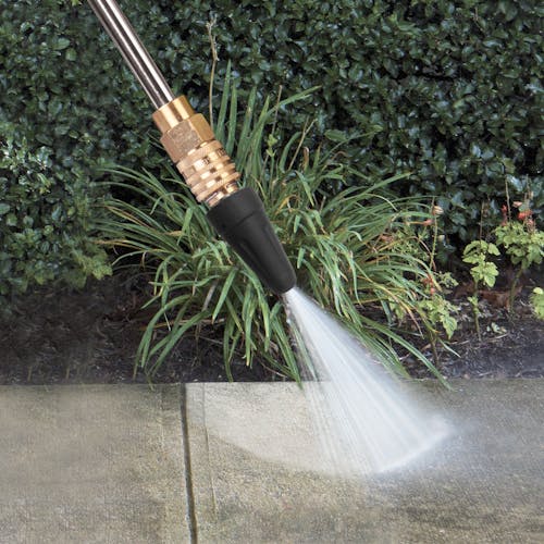 Spray wand being used to remove dirt from a sidewalk.