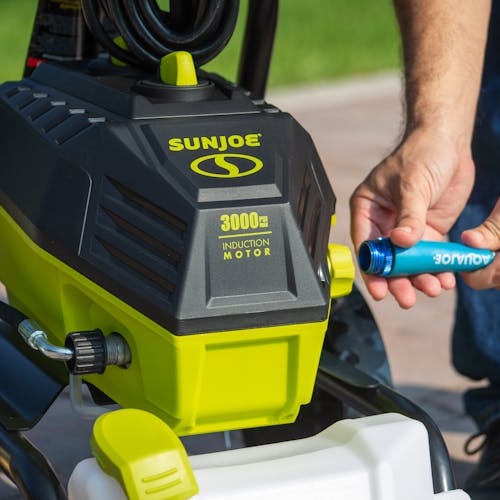 Person connecting a garden hose to the adapter on the Sun Joe 14.5-amp 3000 PSI High Performance Electric Pressure Washer.