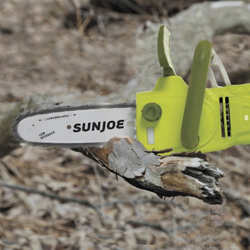 Sun Joe 8-amp 8-inch Electric Convertible Pole Chain Saw cutting through a tree limb.