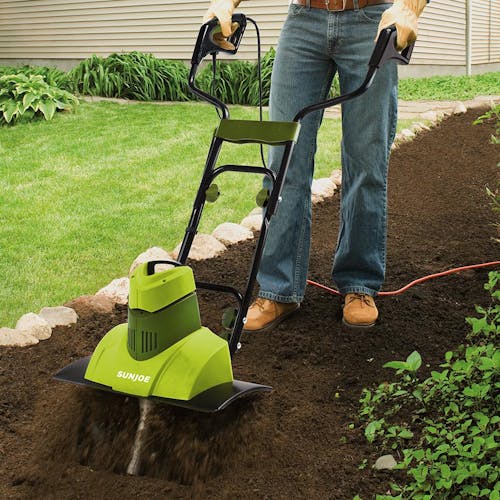 Sun Joe 9-amp 18-inch Electric Tiller and Cultivator being used to cultivate a garden.
