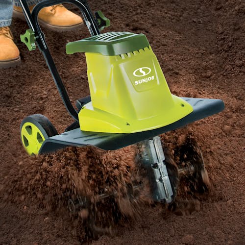 Sun Joe 8-amp 12-inch Electric Tiller and Cultivator being used to till soil.