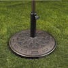 Umbrella stand with metro pattern holding an umbrella on grass.