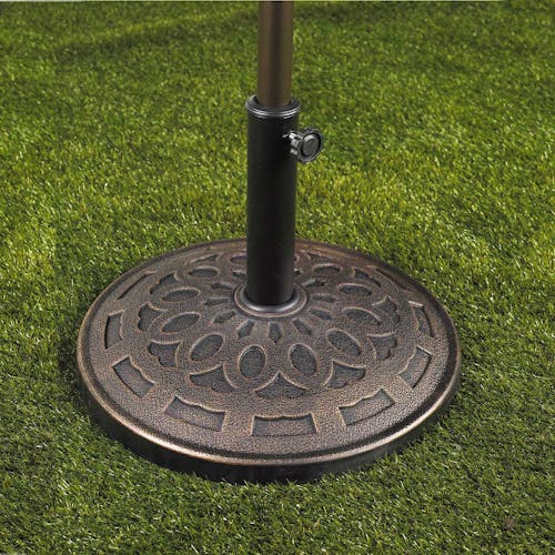 Umbrella stand with metro pattern holding an umbrella on grass.