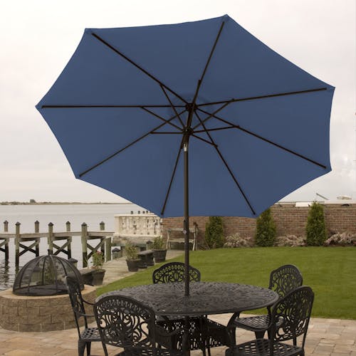 9-foot blue patio umbrella set-up outside over a patio table and chairs.