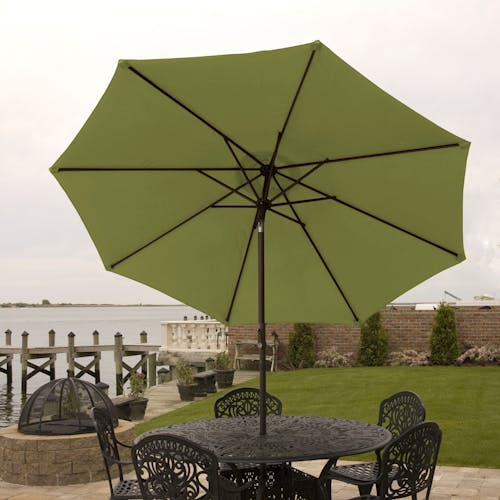 9-foot green patio umbrella set-up outside over a patio table and chairs.