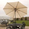9-foot tan patio umbrella set-up outside over a patio table and chairs.