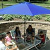 Family eating a meal outside under the 9-foot blue patio umbrella.