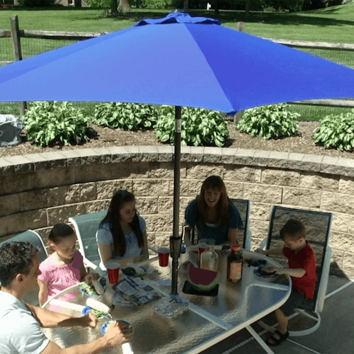 Family eating a meal outside under the 9-foot blue patio umbrella.