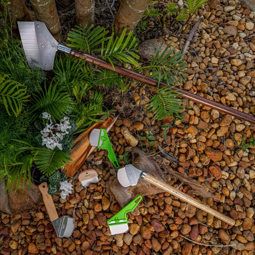 Nisaku Weeders laying on rocks and plants.