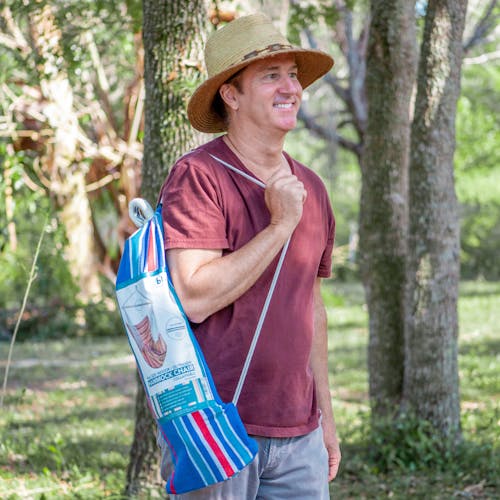 man carrying bliss hammocks fabric hanging chair in included travel bag
