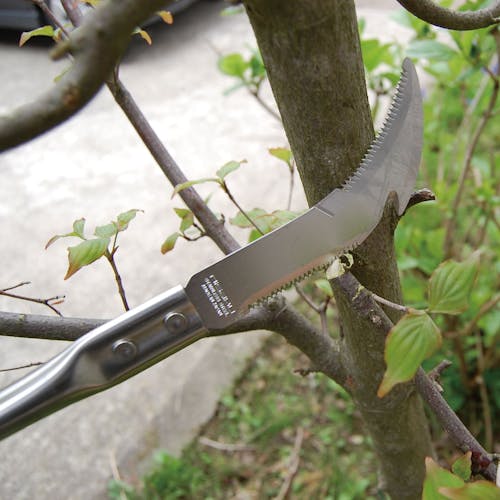 Nisaku 24-inch Scheve Cutter Japanese Stainless Steel Curved Cutter cutting a branch off a tree.