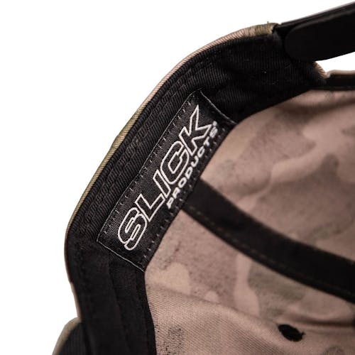 Close-up of the Slick Products tag inside the One-size-fits-all camo snapback hat.