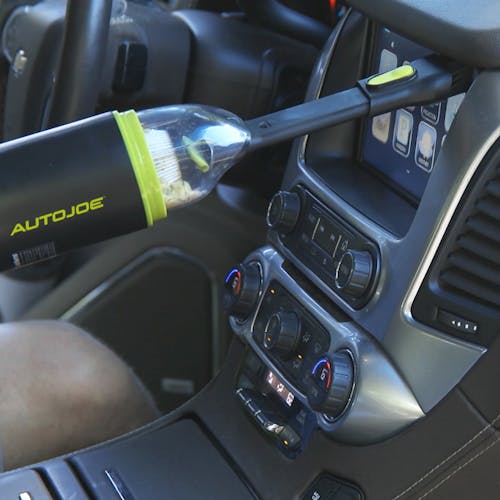 Auto Joe Cordless 8.4-Volt Handheld Vacuum Cleaner with the brush attachment cleaning the car display.